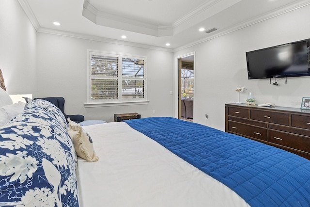 bedroom with ornamental molding and a tray ceiling