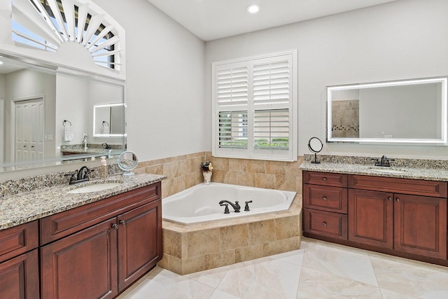 bathroom with vanity and tiled bath