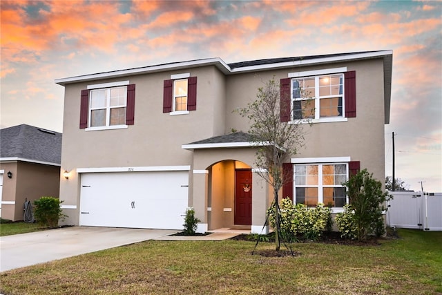 view of front of property featuring a garage and a lawn