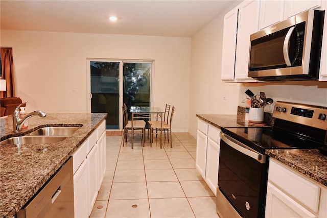 kitchen with sink, light tile patterned floors, stainless steel appliances, white cabinets, and stone countertops