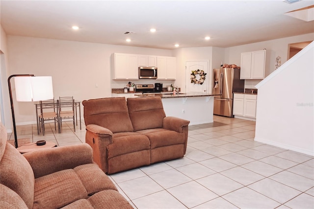 living room featuring sink and light tile patterned flooring