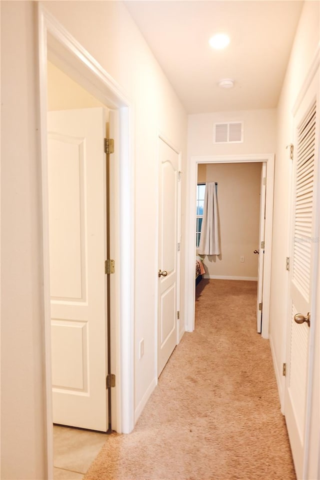 hall with light colored carpet