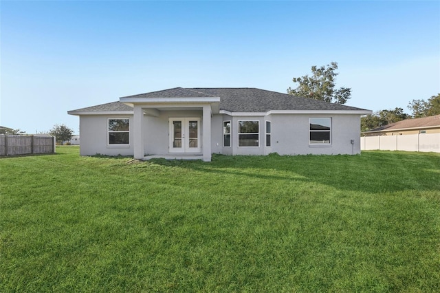 rear view of property featuring french doors and a lawn