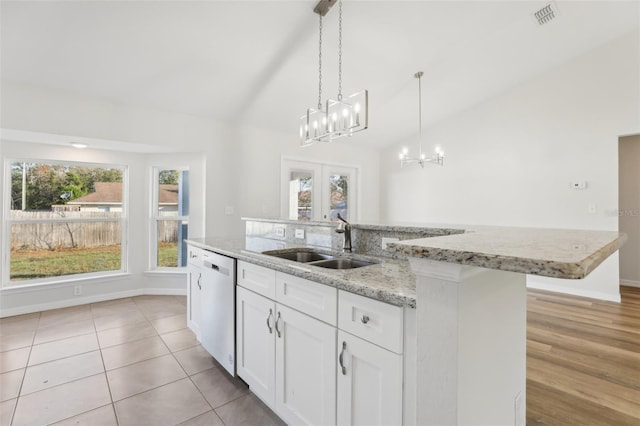 kitchen with sink, vaulted ceiling, dishwasher, an island with sink, and white cabinets