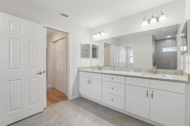 bathroom with vanity, tile patterned flooring, and a tile shower