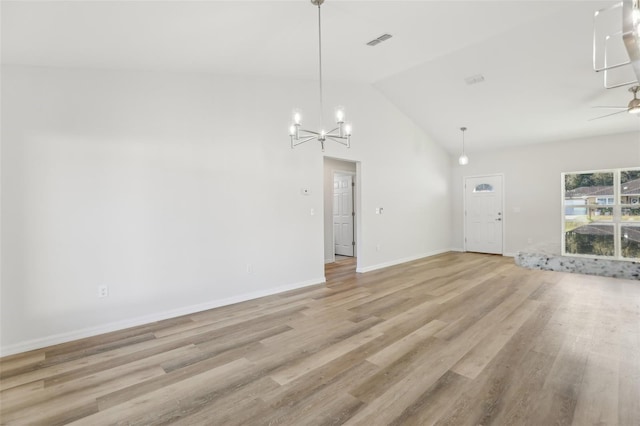 unfurnished living room with high vaulted ceiling, ceiling fan with notable chandelier, and light wood-type flooring