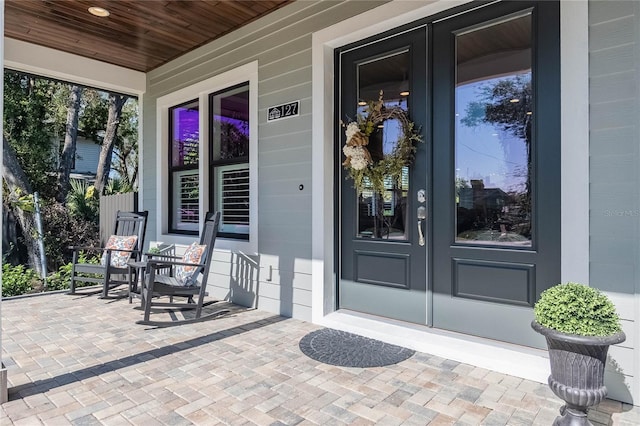 property entrance featuring french doors and a porch