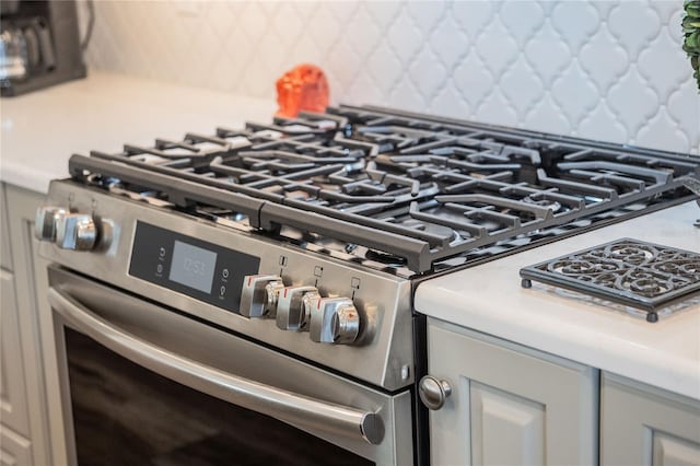 details with backsplash and stainless steel range with gas stovetop