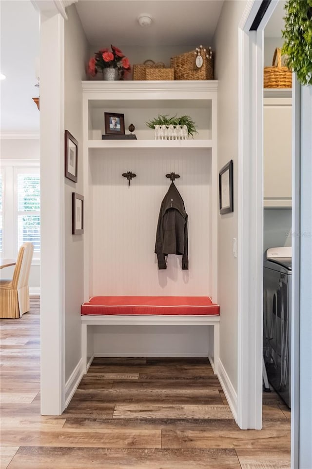 mudroom with washer / clothes dryer, wood-type flooring, and ornamental molding