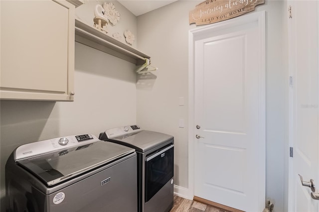 washroom with separate washer and dryer, light hardwood / wood-style floors, and cabinets