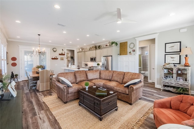 living room with crown molding, ceiling fan with notable chandelier, and hardwood / wood-style floors