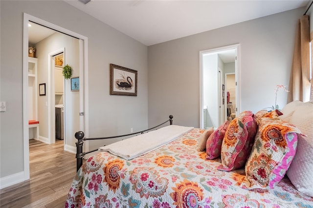 bedroom with ensuite bathroom and light hardwood / wood-style floors