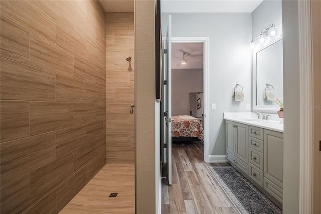 bathroom with vanity, hardwood / wood-style floors, and a tile shower