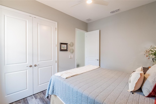 bedroom with hardwood / wood-style floors, a closet, and ceiling fan