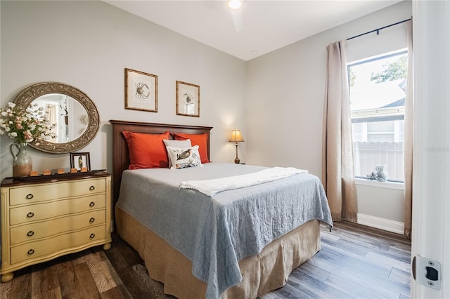 bedroom featuring multiple windows and dark hardwood / wood-style flooring