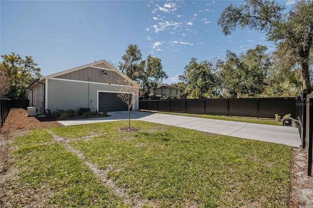 view of yard with a garage and central AC unit