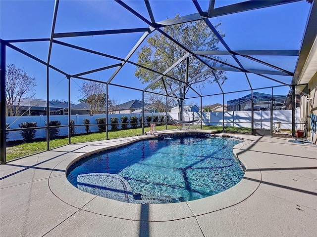 view of swimming pool featuring a patio, a yard, and glass enclosure