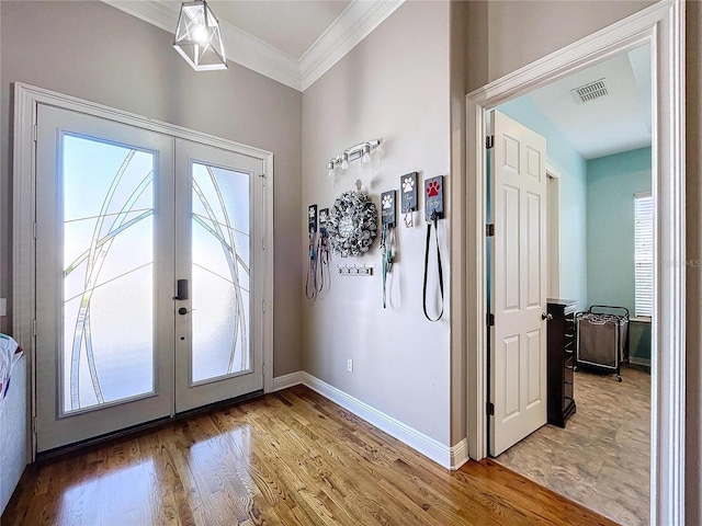 doorway with crown molding, hardwood / wood-style flooring, plenty of natural light, and french doors