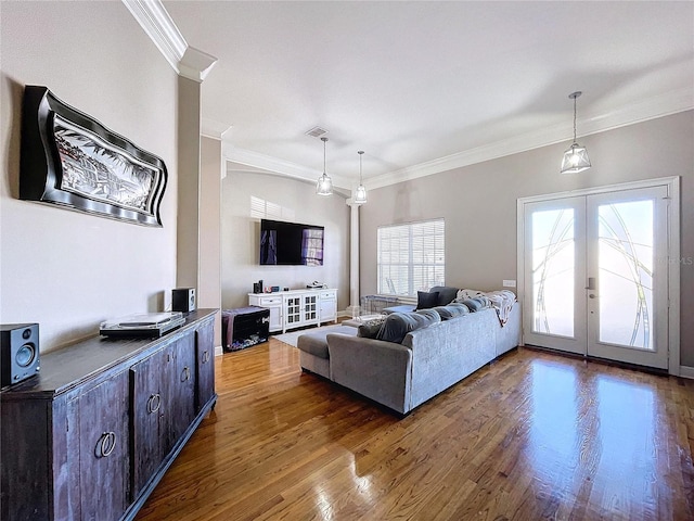 living room featuring french doors, ornamental molding, and hardwood / wood-style flooring