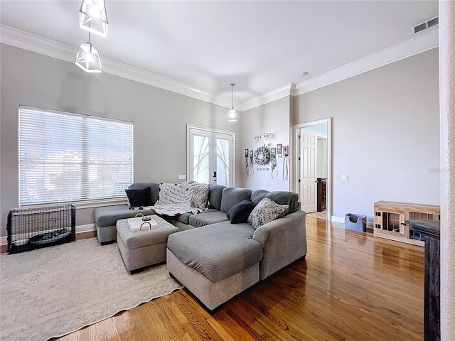 living room with hardwood / wood-style flooring, ornamental molding, and french doors