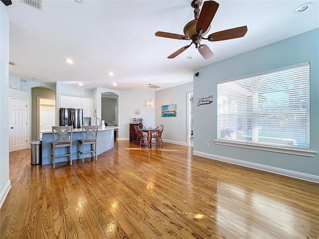 living room featuring ceiling fan and light wood-type flooring