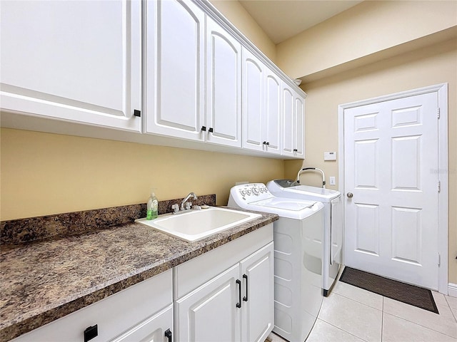 clothes washing area with light tile patterned flooring, cabinets, separate washer and dryer, and sink