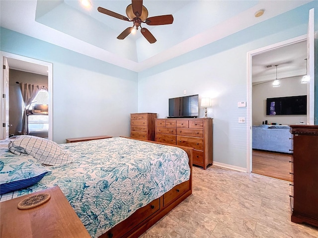 bedroom featuring ceiling fan and a raised ceiling