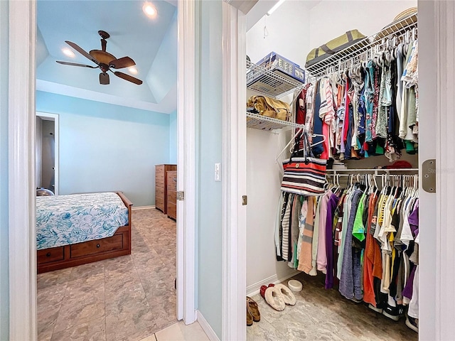 walk in closet with lofted ceiling and ceiling fan