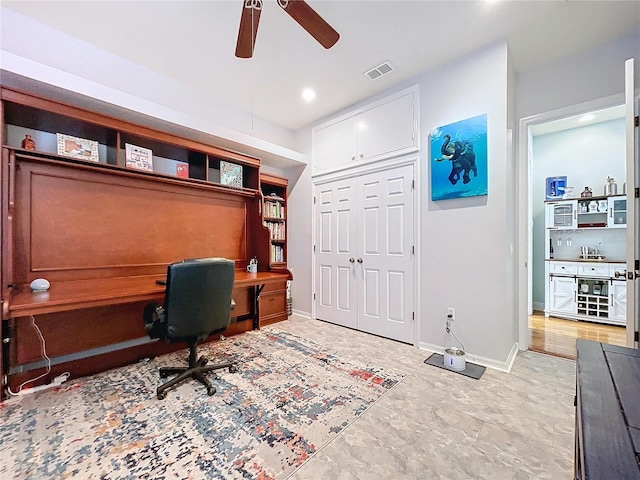 office area with built in desk and ceiling fan