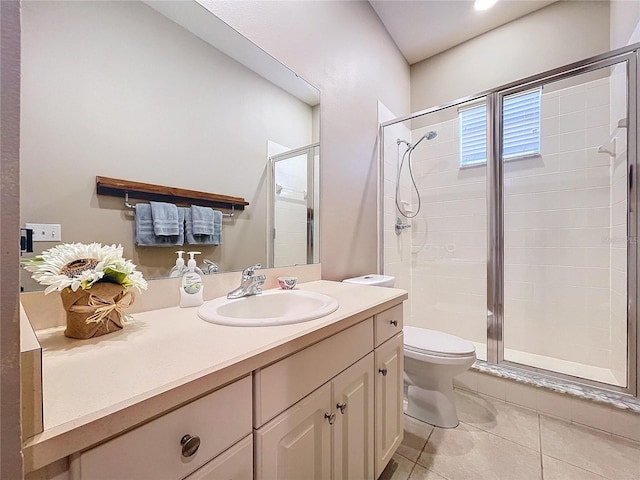 bathroom with a shower with door, vanity, tile patterned floors, and toilet