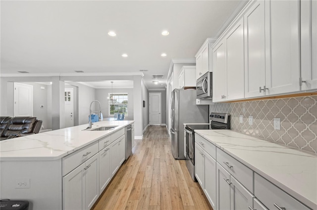 kitchen featuring white cabinetry, sink, stainless steel appliances, crown molding, and light wood-type flooring