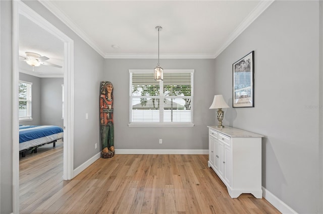 dining room with crown molding, ceiling fan, and light wood-type flooring