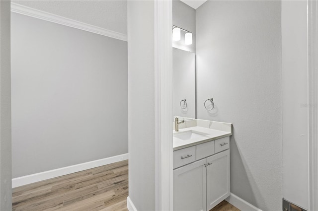 bathroom with crown molding, vanity, and wood-type flooring