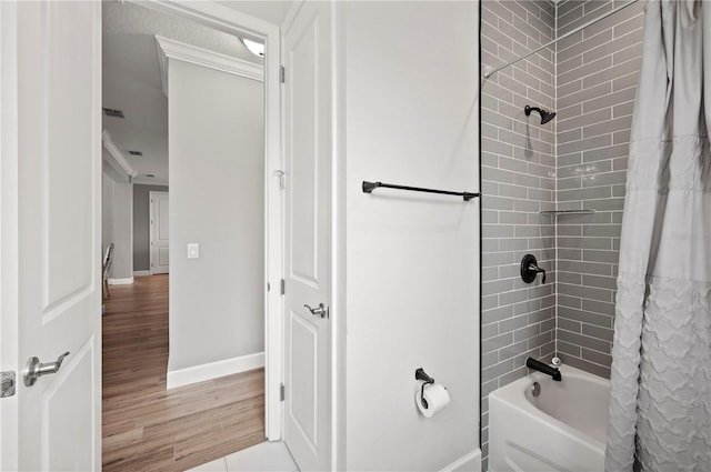 bathroom with hardwood / wood-style flooring and shower / tub combo