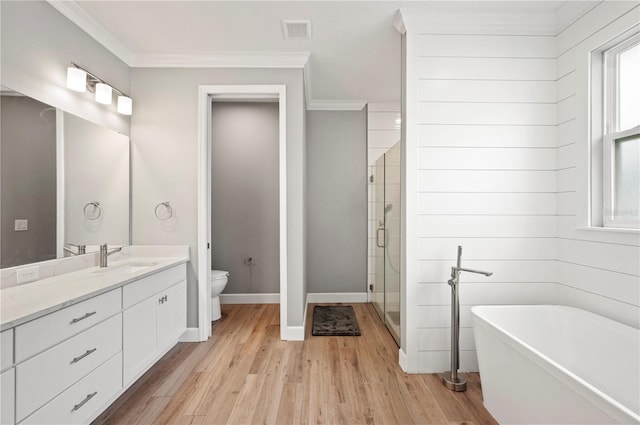 full bathroom featuring shower with separate bathtub, wood-type flooring, vanity, toilet, and crown molding