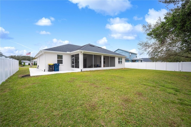 rear view of property featuring a yard, a patio area, and a sunroom