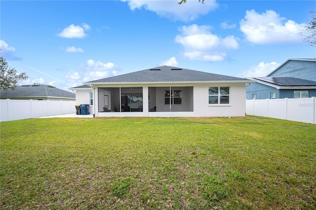 back of property with a yard and a sunroom