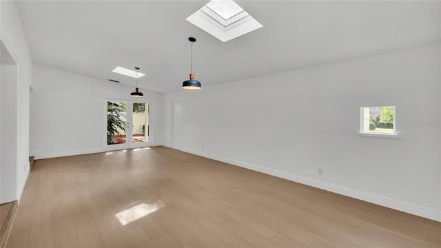 unfurnished room with vaulted ceiling with skylight and light hardwood / wood-style flooring