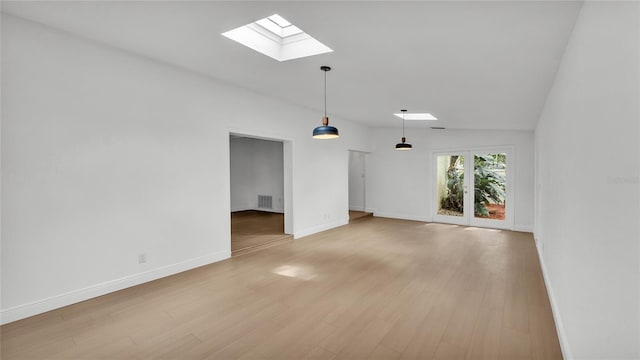 spare room featuring hardwood / wood-style flooring and a skylight