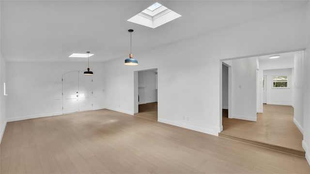 unfurnished living room featuring a skylight and light wood-type flooring