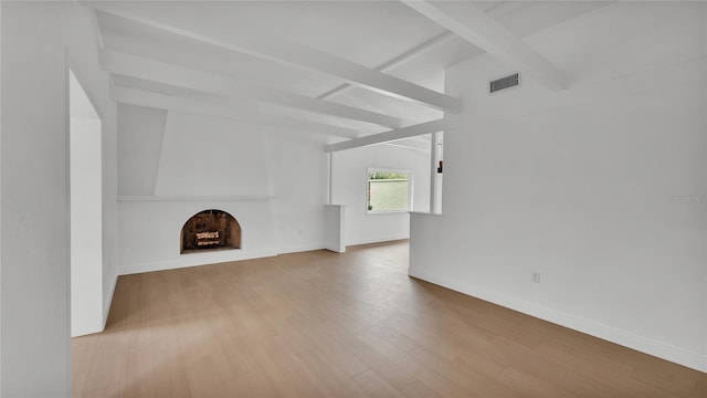 unfurnished living room featuring beamed ceiling and wood-type flooring