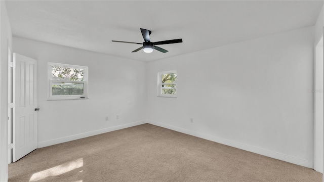 carpeted empty room featuring ceiling fan and a healthy amount of sunlight