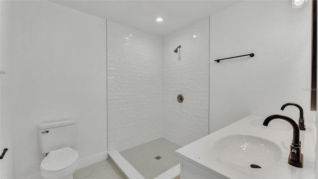 bathroom featuring vanity, toilet, and a tile shower