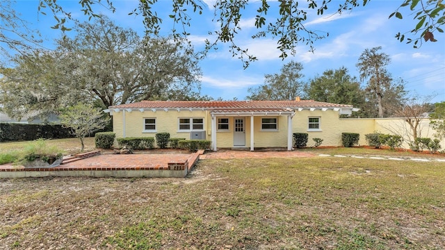 view of front of house featuring a patio and a front lawn