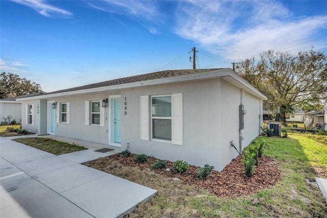 ranch-style home with cooling unit and a front yard