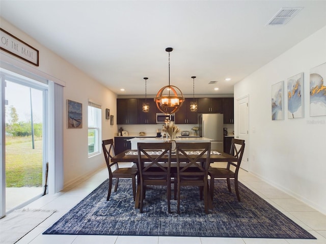 tiled dining area with a chandelier