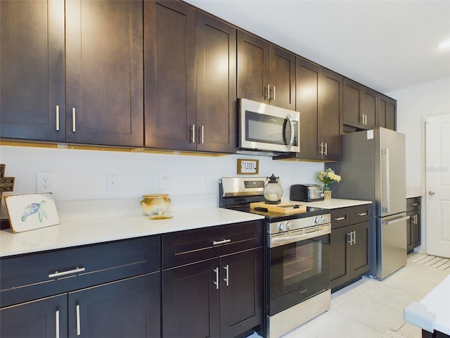 kitchen featuring appliances with stainless steel finishes, light countertops, dark brown cabinetry, and light tile patterned flooring