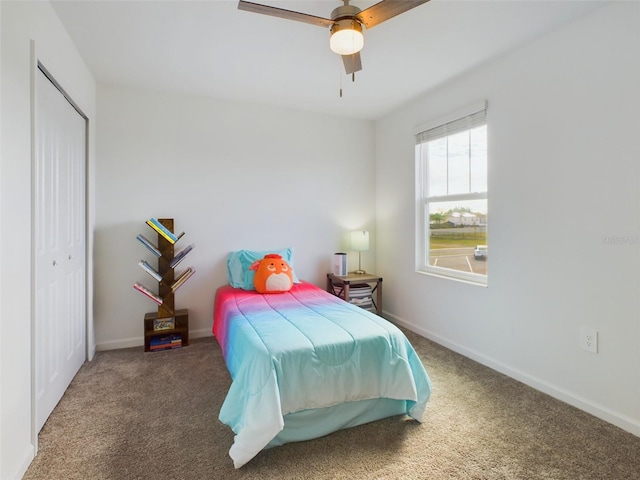 carpeted bedroom with ceiling fan and a closet