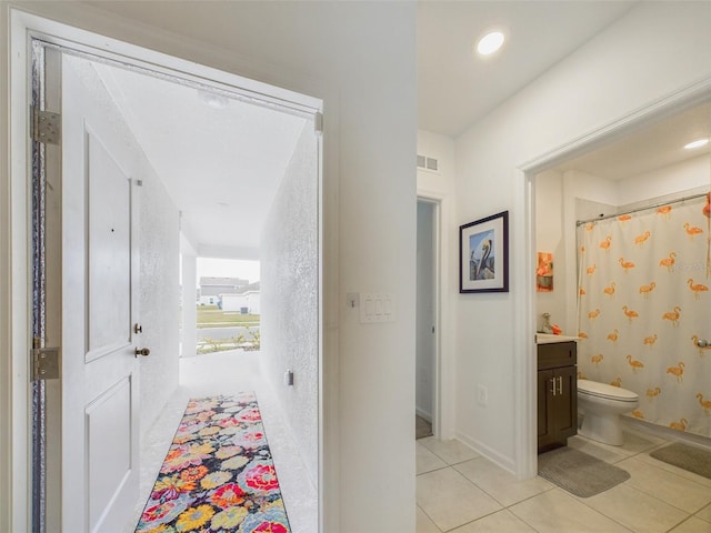 hall with recessed lighting, visible vents, and light tile patterned flooring