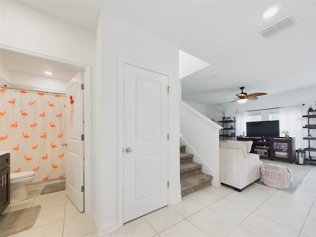 stairs featuring ceiling fan and tile patterned flooring